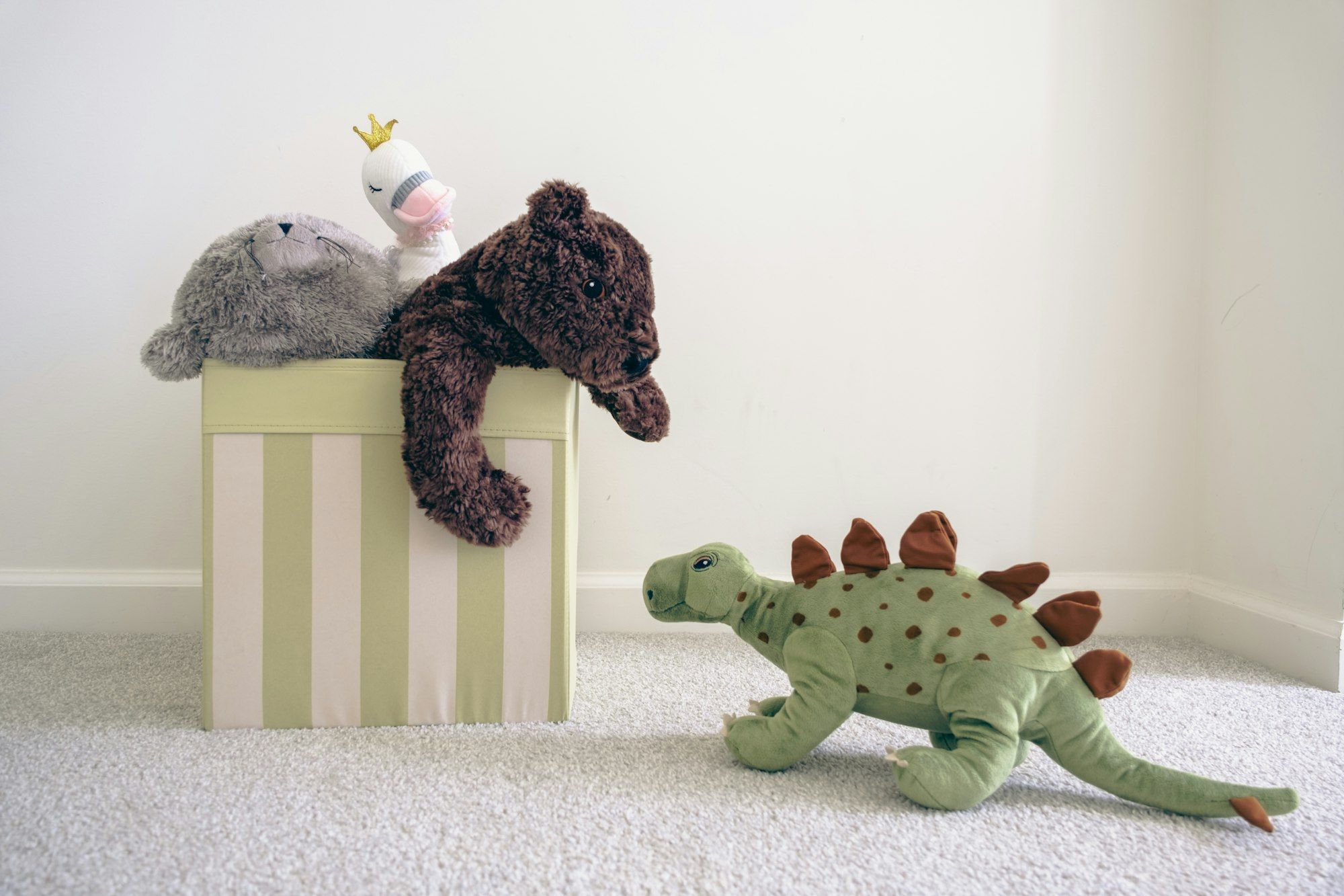 Soft toys sitting on and around a striped box